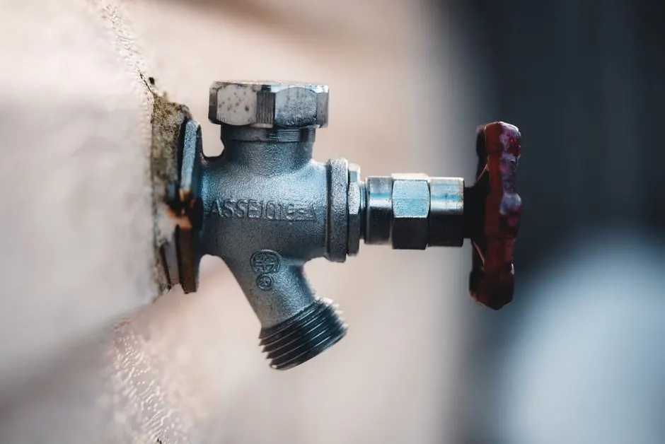 Close-up of a metal water shutoff valve mounted on a wall